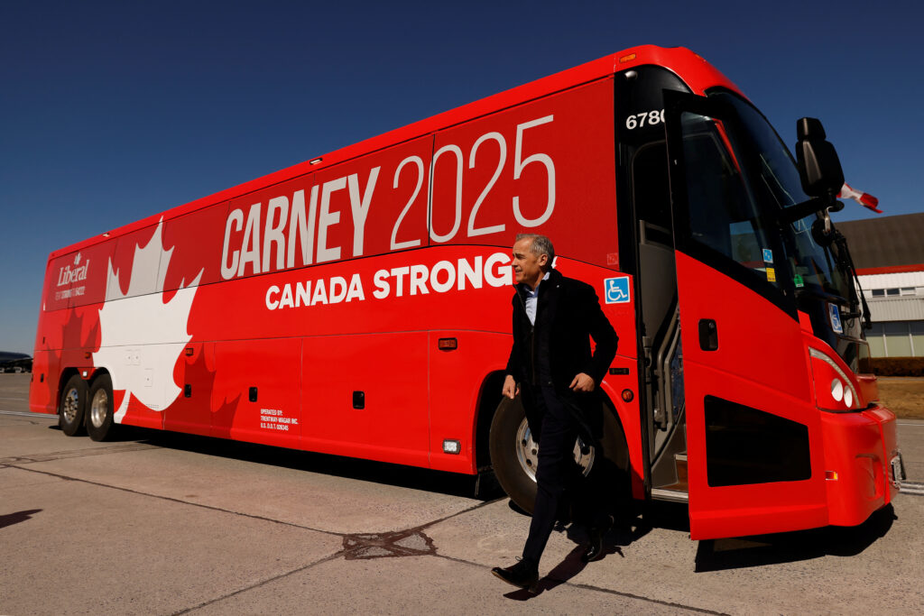 Canada's Prime Minister Mark Carney exits his campaign bus, before boarding an aircraft, after calling for an election, in Ottawa, Ontario, Canada March 23, 2025. REUTERS/Blair Gable