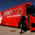 Canada's Prime Minister Mark Carney exits his campaign bus, before boarding an aircraft, after calling for an election, in Ottawa, Ontario, Canada March 23, 2025. REUTERS/Blair Gable